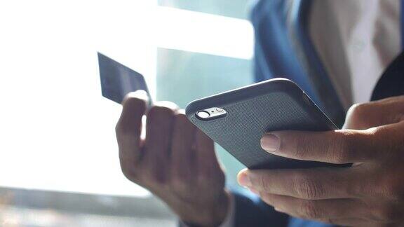 商人在手机上插入信用卡号码慢动作