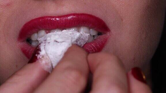 咬土耳其软糖的女人的牙齿