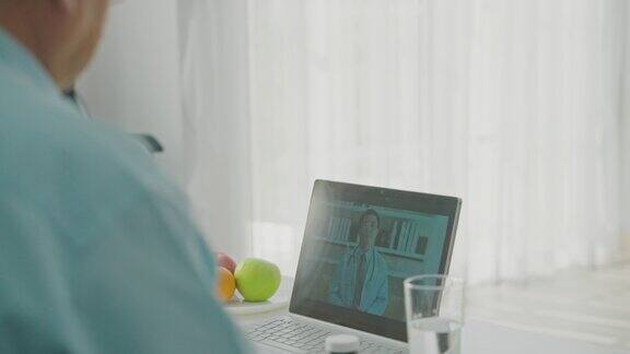 老年夫妇病人在家里用数码平板电脑和男医生聊天