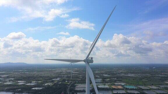 空中拍摄的风力涡轮机与蓝天和农场在乡村