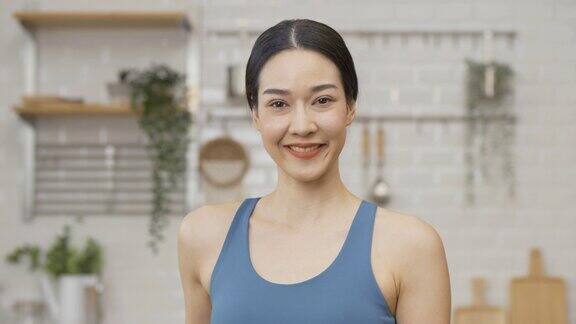 美丽的亚洲女人在厨房在家里她面带迷人的微笑望着镜头保健和饮食