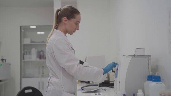 穿着制服的女医生在实验室办公室用显微镜进行分析在实验室工作的科学家在现代医学实验室工作的微生物学家