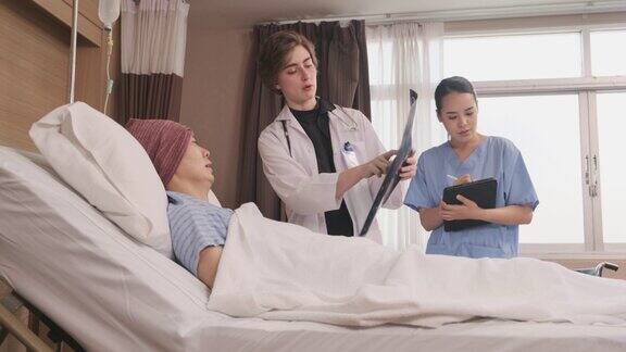 女医生在医院的住院病房床上给病人讲解x光片