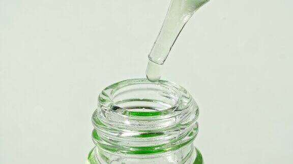 透明的化妆品凝胶液吸管中的气泡滴入瓶中天然有机化妆品医药生产特写慢动作