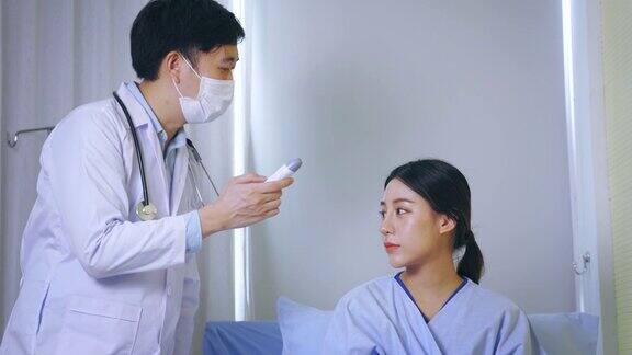 年轻男耳鼻喉科医生带听诊器在医院用鼓室温度计测温度检查穿制服的亚洲女病人