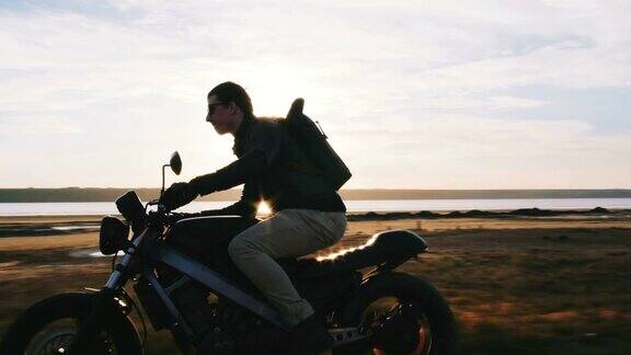 日落时分摩托车手在路上开着他的摩托车