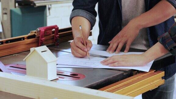 两个木匠工人在车间内嵌式家具项目中设计施工的特写