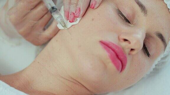 特写的一个美容师给一个女人的脸颊注射美容诊所的美容及拉皮消脂biorevitalization美容