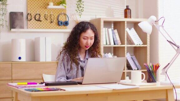 精力充沛的亚洲女商人工作在笔记本电脑从家庭办公室使用电脑远程学习浏览网页虚拟会议在电脑上打字新常态生活方式