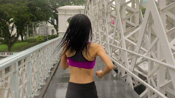 一名中年亚洲妇女在新加坡雨中慢跑