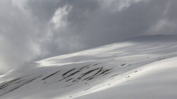 高海拔、无树、光滑的雪山坡上的暴风云