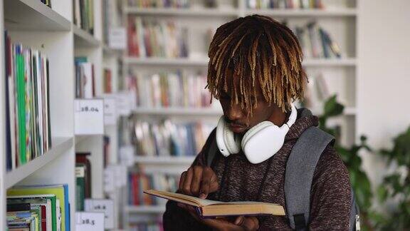 一个非洲学生站在图书馆看书