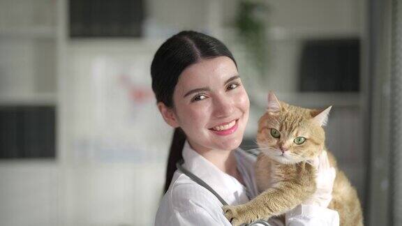女兽医抱着一只可爱的小猫看着镜头微笑着