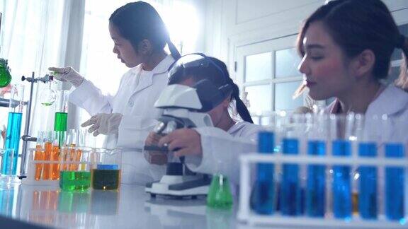 年轻的女教师和两名亚塞恩女孩私立小学的STEM学生进行科学实验