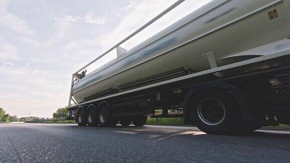 在高速公路上行驶的装有燃料柴油拖车的货运卡车白色卡车在清晨运送货物