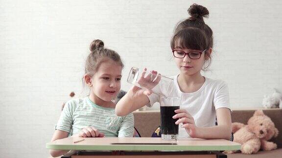 孩子们进行化学实验并对化学反应感到惊讶两个小女孩在化学实验室玩