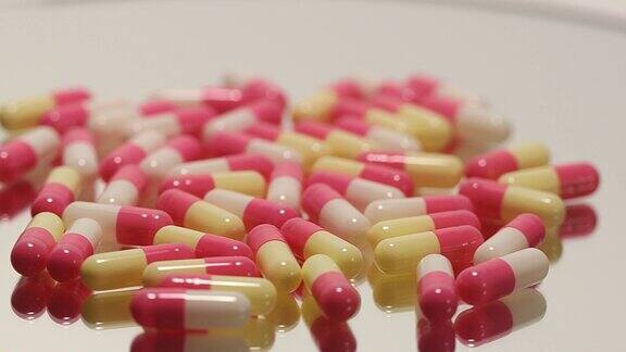 粉色、白色药丸和药瓶放在一个旋转平台上
