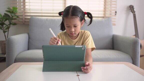 小女孩在家用数字平板电脑自学
