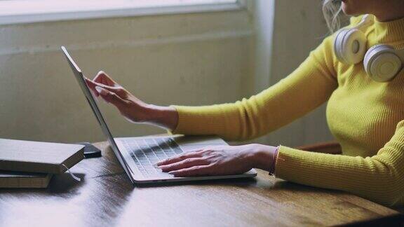 女性的手在笔记本电脑键盘上打字