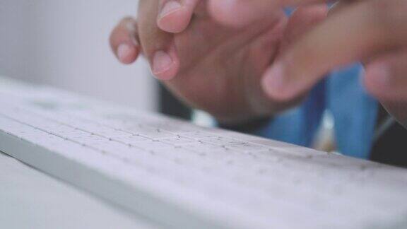 特写商人的手在笔记本电脑键盘上打字