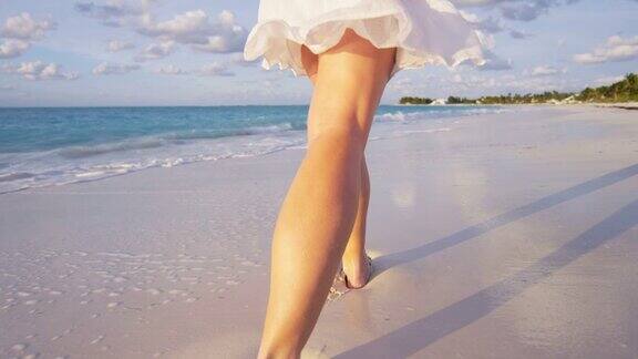 光脚的白人女性享受岛屿日落的腿