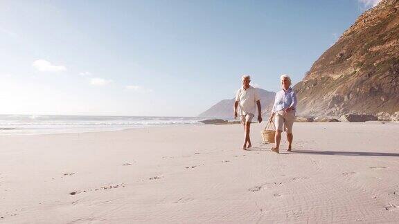 爷爷奶奶提着野餐篮在海滩上孙子孙女们跑在前面