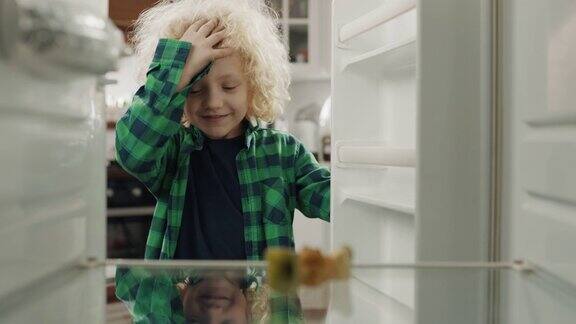 饥饿绝望的男孩看着空空的冰箱