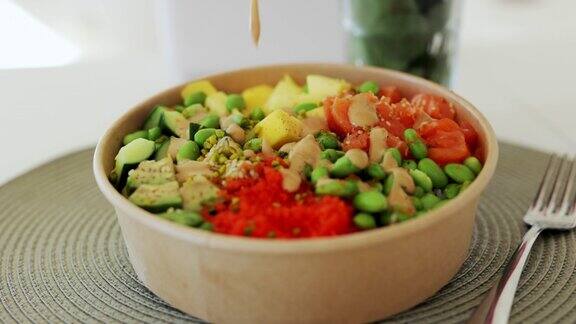 将三文鱼、牛油果、毛豆、黄瓜和萝卜放在一个灰色的碗里夏威夷碗白色背景饮食适当的营养和健康proress422