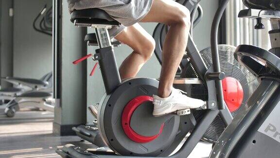 男性在健身房里骑自行车锻炼肌肉