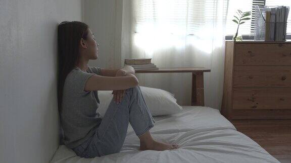 一个亚洲女人独自坐在卧室里她患有抑郁症她总是有压力和焦虑