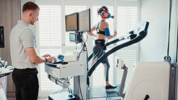 运动科学家正在中心对一名运动员进行代谢气体分析测试健康、活跃、健康、运动的女性戴着口罩在跑步机上跑步进行呼吸测试有氧运动性能