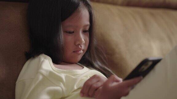 睡觉前坐在沙发上玩智能手机的女孩