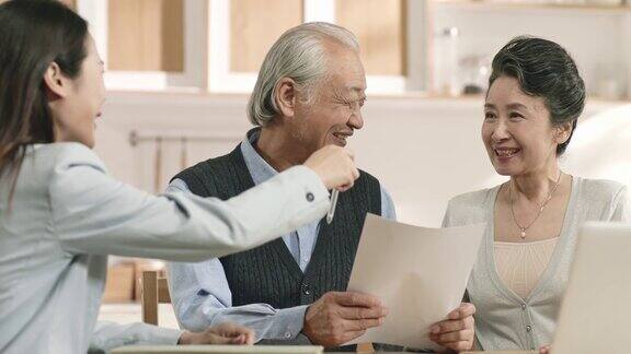 年长的亚洲夫妇愉快地签署协议