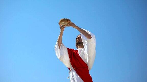 耶稣神举起手中的面包向天空祝福圣餐圣餐
