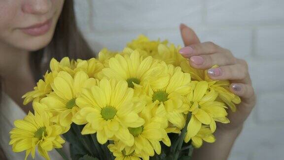 一个女孩手里捧着一束黄色的菊花