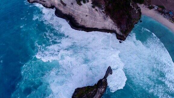 航拍海湾碧蓝的海水岩石峭壁和海浪碰撞