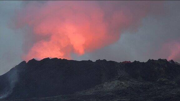 冰岛火山喷发大自然的奇迹炽热的熔岩从地面喷发出来无人机在活跃的火山口上空飞行熔岩穿过深色岩石表面凝固开裂