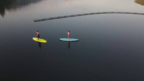 在泰国热带湖泊用桨冲浪