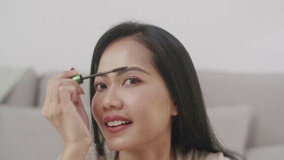 美丽的亚洲女性使用睫毛夹