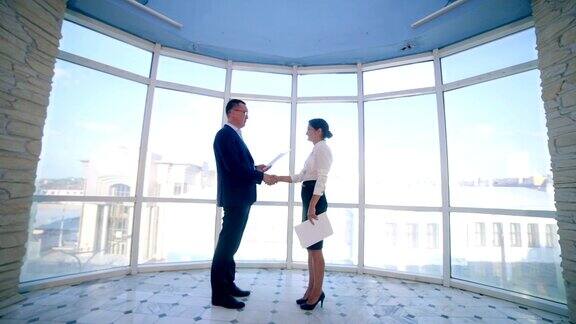 商业、房地产概念男人和女人在办公室握手