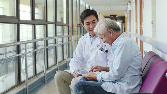年轻的亚洲医生向年长的病人展示化验结果