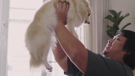 快乐的人抱着他的狗一起在家里玩