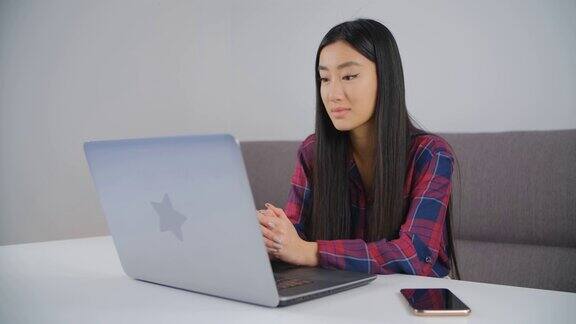 亚洲学生和远程学习美丽的越南女孩听在线教师视频电话来自越南的年轻女子使用笔记本电脑和互联网进行教育