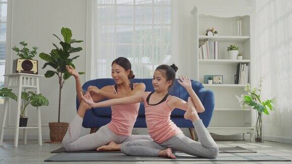母亲和女儿在家里练习瑜伽美人鱼姿势