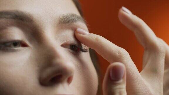 化妆的步骤一个女人在化妆时用手指在眼睑上涂眼影的特写