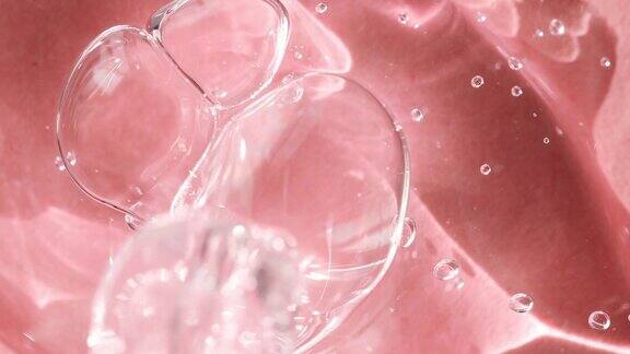 透明的身体血清在粉红色的背景俯视图化妆品滴管液体肥皂洗发水特写