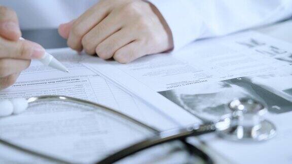 职业医生穿制服记日记内科治疗师在病历板上填写病历病史和处方与病人交谈