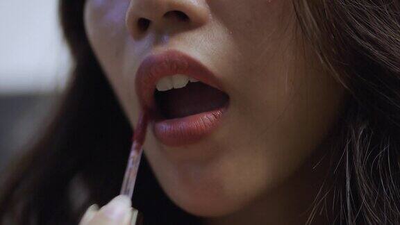 女人用口红涂嘴唇的特写镜头