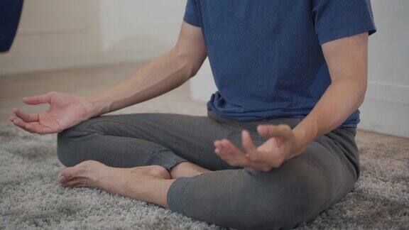 年轻的亚洲男子在家里做放松练习瑜伽