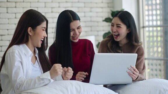 女性在网上做生意一群快乐的亚洲女人坐在床上用笔记本电脑进行视频通话一起在网上销售